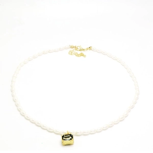 Detail van parelketting met zwarte koffer hanger en gouden Love Forever inscriptie