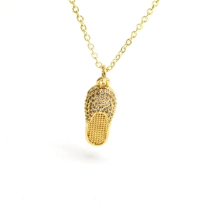 Detailed close-up of golden flip-flop pendant with sparkling rhinestones and delicate chain