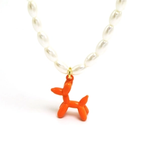 Collier de perles chic avec un pendentif chien ballon orange vif sur fond blanc