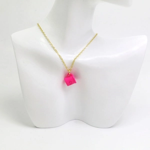 Détail du collier avec pendentif tasse à café rose rouge sur chaîne dorée sur un buste