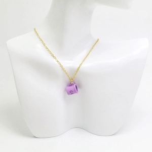 Collier à chaîne fine dorée avec pendentif tasse à café violette sur un mannequin