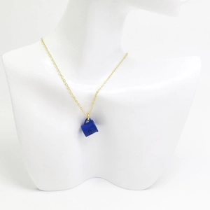 Gros plan détaillé d'un collier en chaîne dorée avec un pendentif tasse à café bleu