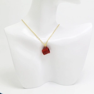 Détail d'un collier chaîne dorée avec pendentif tasse à café rouge et lettrage CO gravé