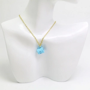 Détail du pendentif tasse à café bleu clair créatif sur une fine chaîne dorée