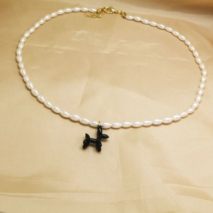Détail du collier de perles avec pendentif chien ballon noir et fermoir mousqueton doré