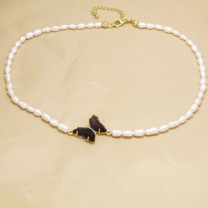 Detalle del collar de perlas con colgante de mariposa de cristal púrpura y perlas naturales