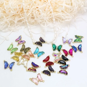 Primer plano de colgantes de mariposa de cristal coloridos con bordes dorados para collar