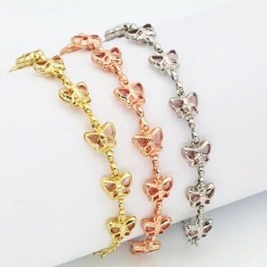 Nahaufnahme minimalistischer Schmetterlingsarmbänder in Gold, Roségold und Silber.