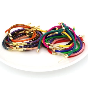 Close-up of colorful nylon braided cords with gold plated metal tubes for DIY jewelry