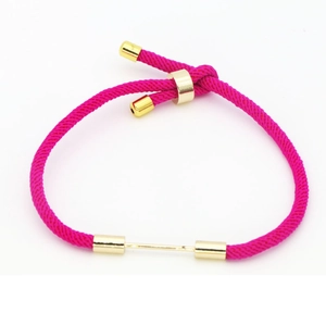 Detail of adjustable rose red nylon cord bracelet with golden metal bar and sliding clasp