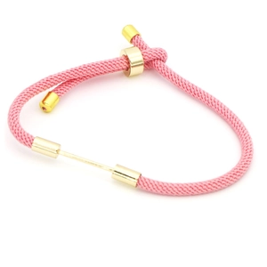 Macro shot of pink nylon braided bracelet with adjustable gold slider buckle and metal bar