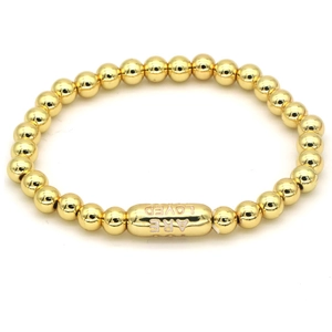 Detailed macro view of 18k gold-plated beads and Are Loved engraved capsule charm