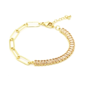 Dettaglio della catena dorata a graffetta e bracciale con zirconi rettangolari color champagne