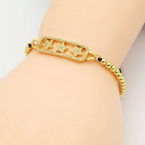 Pulsera tejida dorada con un dije rectangular decorado con tres estrellas brillantes