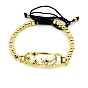 Detalle de pulsera de cuentas con estrellas doradas y colgante de luna con circón