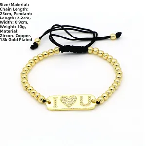 Dettaglio di un bracciale a sfere dorate regolabile con placca rettangolare I Heart U in zirconi