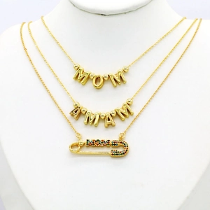 Detailed close-up of gold-plated Mama necklace set with colorful zircon pavé safety pin