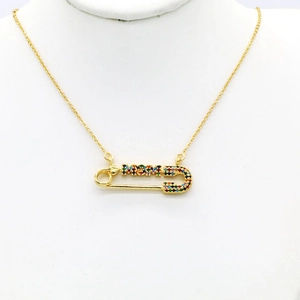 Close-up of gold safety pin necklace with MOM engraving and multicolor crystals