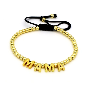 Adjustable golden MAMA beaded bracelet with black braided rope on white background
