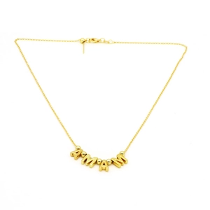 Macro detail of gold AMAM letter pendant necklace with metallic beads on fine chain
