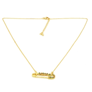 Detail of gold safety pin necklace with colorful zircon stones spelling MOM on white backdrop