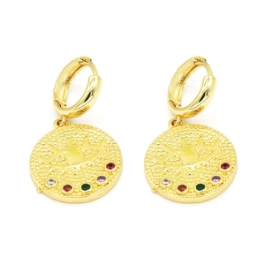 Détail de boucles d'oreilles dorées avec motif œil et pierres précieuses colorées