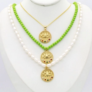Détail de colliers en or, perles et perles vertes avec pendentifs œil protecteur