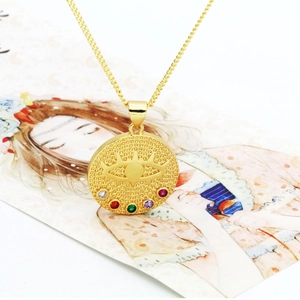 Gros plan d'un pendentif œil protecteur doré serti de cinq zircons multicolores