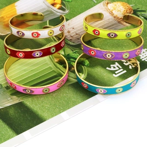 Macro detail of Hamsa Hand and Evil Eye enamel open cuffs in various vibrant colors