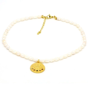 Détail d'un collier de perles avec pendentif œil maléfique doré et pierres multicolores