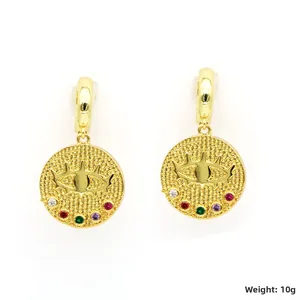 Détails des boucles d'oreilles dorées avec motif oeil protecteur et cristaux colorés