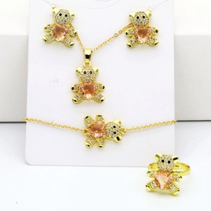 Détail d'une parure ours doré avec pierres de cœur roses et strass blancs brillants