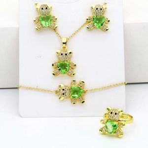 Ensemble de bijoux détaillés avec oursons dorés et pierres vertes en forme de cœur