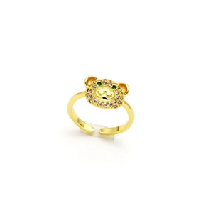 Détail d'une bague ours dorée avec zircons brillants et yeux en pierres vertes