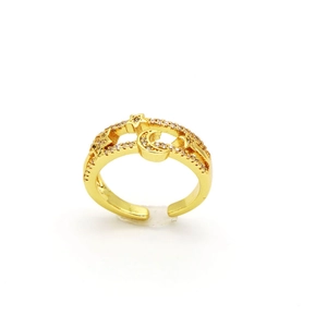 Vue macro d'une bague ajustable dorée avec pavé de zircons en forme d'étoile et de lune