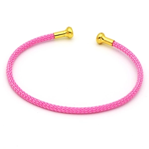 Dettaglio del bracciale intrecciato rosa a forma di C con estremità a sfera in metallo oro