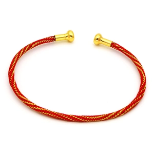 Dettaglio del bracciale rigido intrecciato rosso e oro con punte tonde in metallo