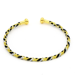 Dettaglio di un bracciale rigido intrecciato a tre colori con punte sferiche dorate