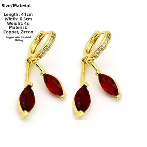 Detalle de pendientes de cereza con circonitas rojas y cobre bañado en oro de 18 quilates
