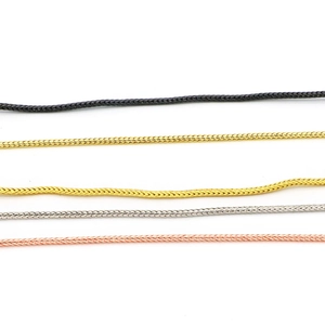 Dettaglio di cinque catene a serpente colorate in nero, oro, argento e oro rosa