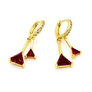 Detalle de pendientes de flecos dorados con piedras rojas y circonitas brillantes