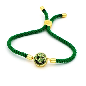 Detail of adjustable green braided rope bracelet with a gold smile face charm and zircon