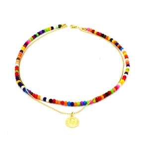 Detail of double-layer necklace with vibrant colorful beads and gold embossed pendant
