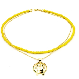 Detail of double-layer gold chain necklace featuring a cat pendant and yellow beads