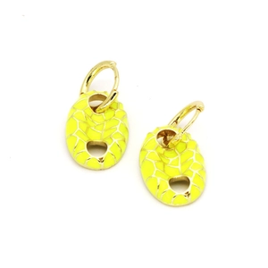 Macro shot of gold-plated pig nose earrings with yellow enamel and gold grid patterns