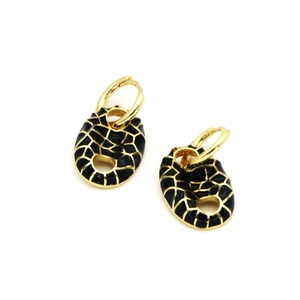 Detail of gold hoop earrings with black enamel oval pendants featuring a grid pattern
