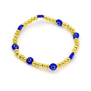 Dettaglio del bracciale malocchio con sfere di metallo dorato e perle Nazar blu
