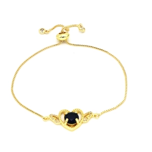 Elegant gold heart bracelet with blue zircon centerpiece and sparkling pavé wings