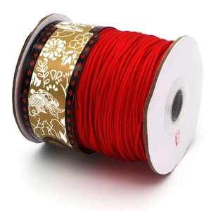 Grosse bobine de cordon tressé rouge vif pour bijoux avec motif floral sur le support