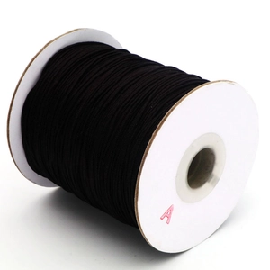 Détail du cordon en nylon tressé noir sur une bobine pour la création de bijoux